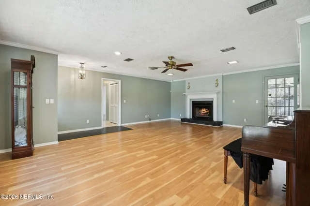a view of empty room with wooden floor and fireplace