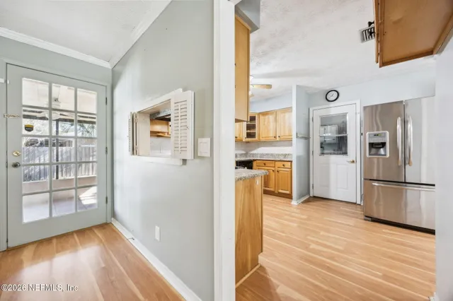 a view of a kitchen with refrigerator and wooden floor