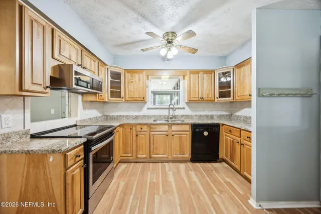 a kitchen with stainless steel appliances granite countertop a sink stove and cabinets