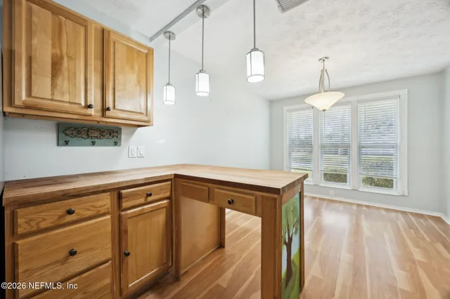 a view of a kitchen with wooden floor and cabinets