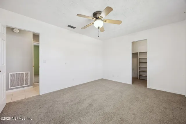 a view of an empty room with a ceiling fan