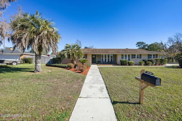 a view of swimming pool with outdoor seating and house in the background
