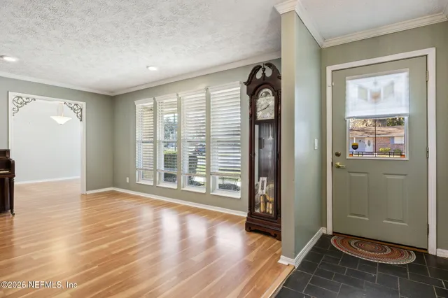 a view of an empty room with glass door and wooden floor