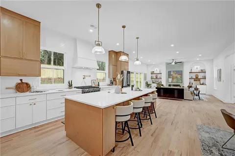 a large kitchen with kitchen island a sink table and chairs