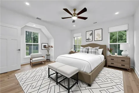 a spacious bedroom with a bed a couch and a large window