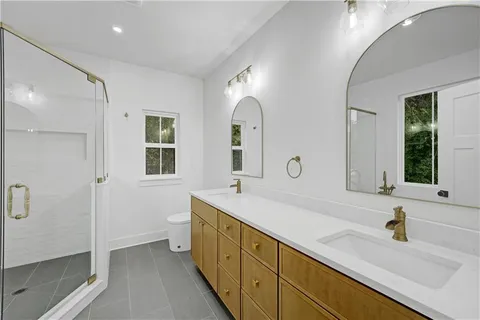 a spacious bathroom with a double vanity sink mirror and shower