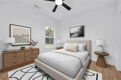 a bedroom with a bed and a large mirror on the dresser