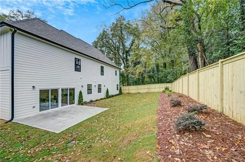 a view of a backyard with large trees and plants