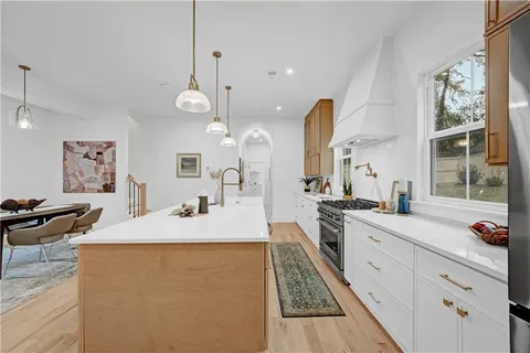 a large kitchen with granite countertop a sink a counter space appliances and cabinets