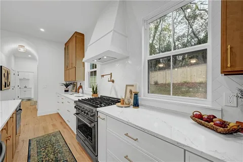 a kitchen with stainless steel appliances a sink a stove and a window