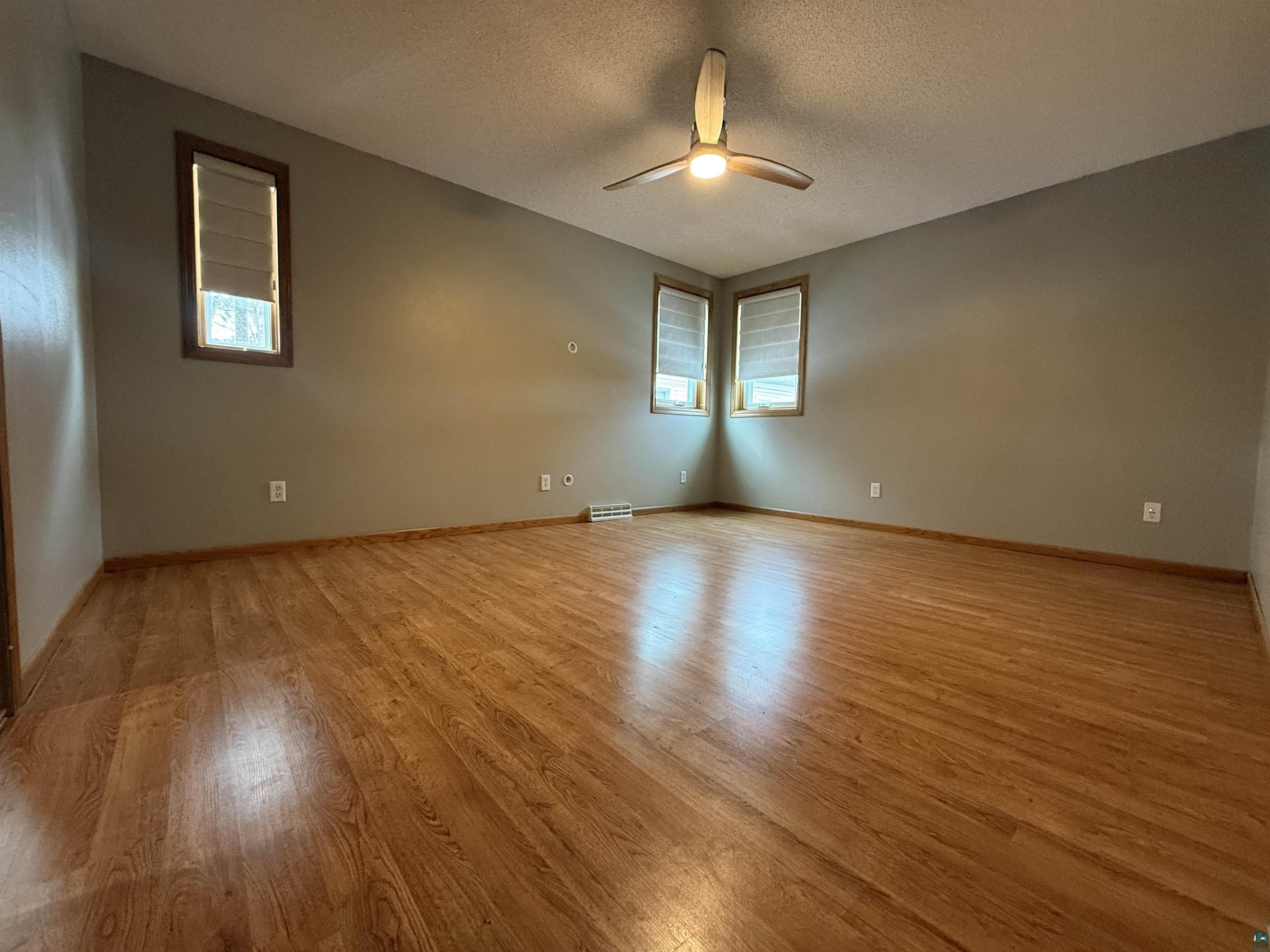 1321 South 13th Street Virginia, MN 55792 - Photo 17 of 33 Spare room with light wood-style flooring, a textured ceiling, ceiling fan, and plenty of natural light