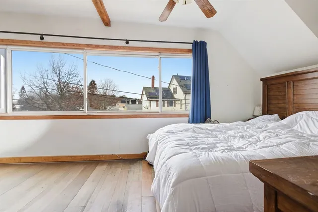 a bed sitting in a bedroom next to a window