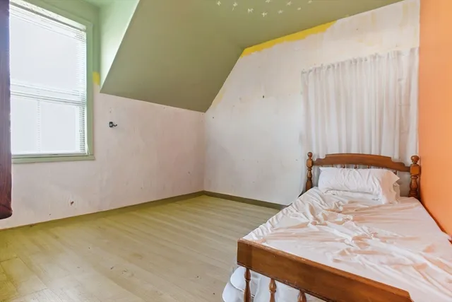 a view of a bedroom with a bed and a window