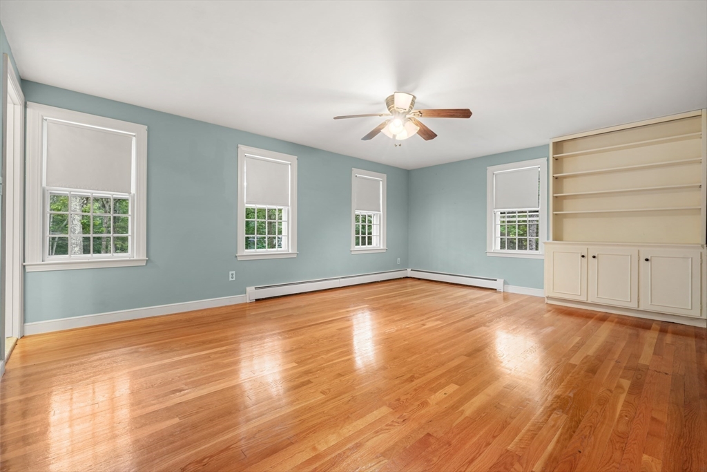 188 Country Drive, Unit 188 Weston, MA 02493 - Photo 15 of 21 a view of an empty room with a window and wooden floor