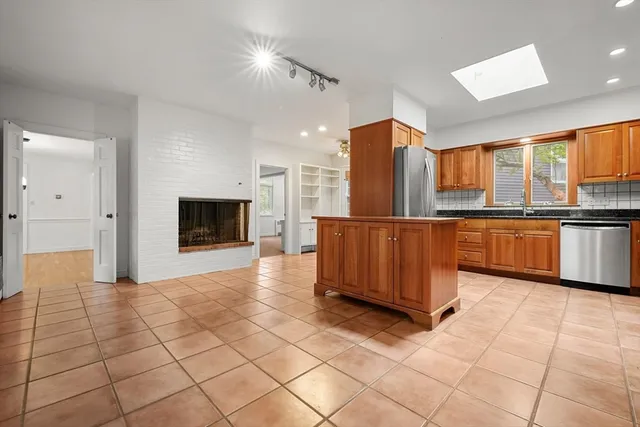 a view of kitchen with stainless steel appliances kitchen island granite countertop a refrigerator and a stove top oven