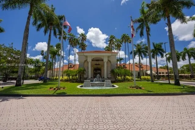 a front view of a multi story residential apartment building with yard and green space