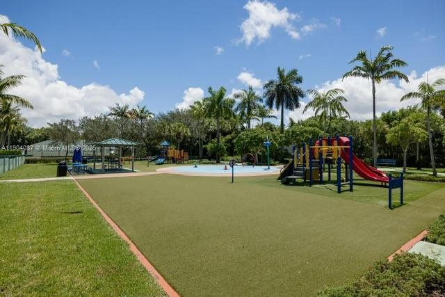 9725 Northwest 52nd Street, Unit 415 Doral, FL 33178 - Photo 19 of 24 a view of a swimming pool with a bench and trees