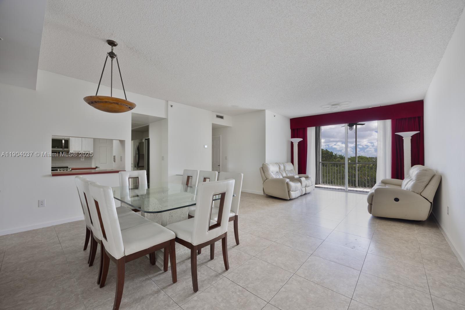 9725 Northwest 52nd Street, Unit 415 Doral, FL 33178 - Photo 5 of 24 a dining room with furniture a chandelier and a rug