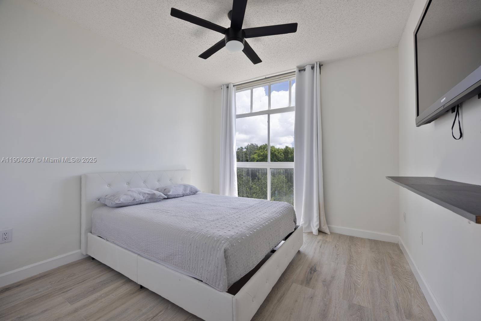 9725 Northwest 52nd Street, Unit 415 Doral, FL 33178 - Photo 6 of 24 a bedroom with a bed and a window