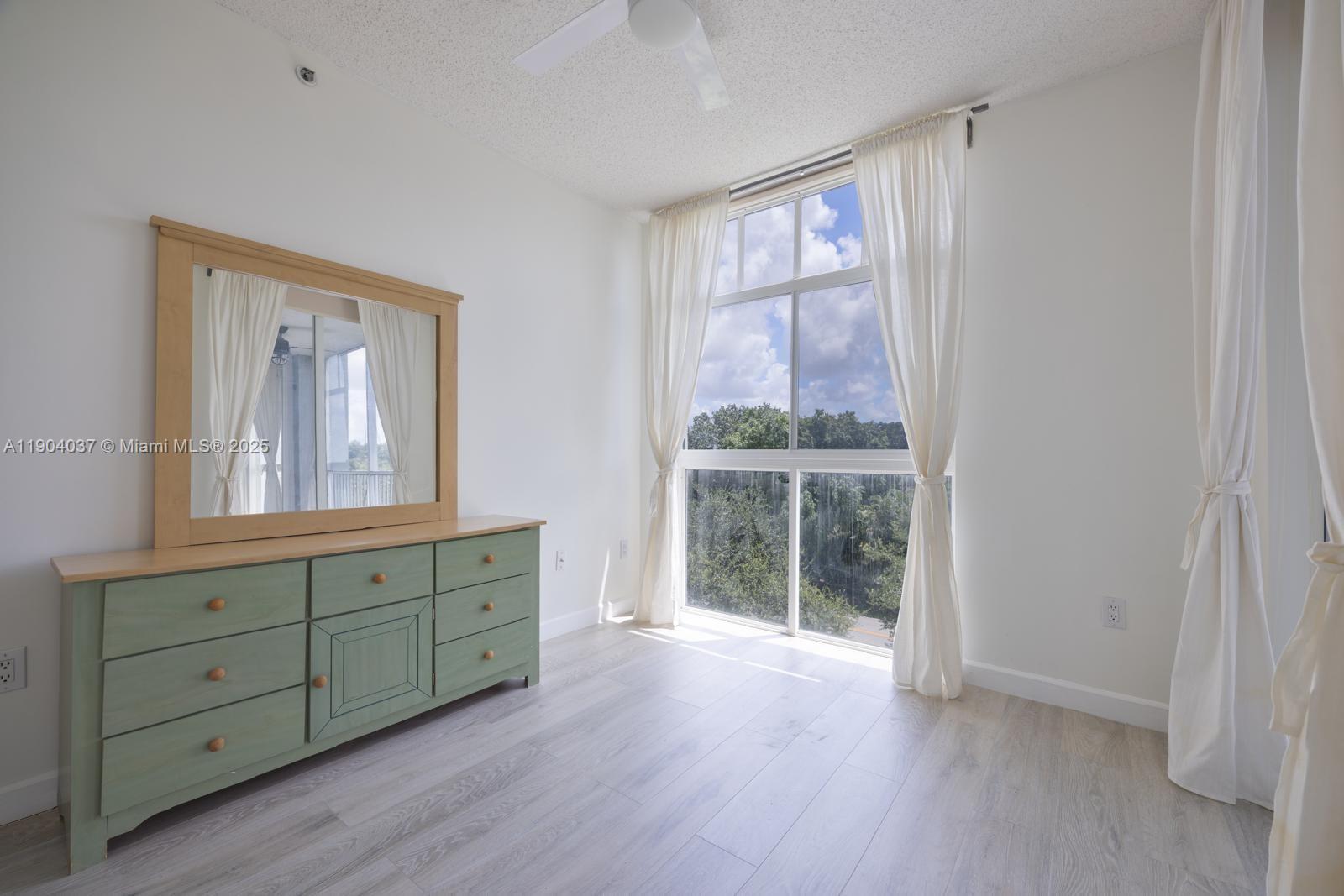 9725 Northwest 52nd Street, Unit 415 Doral, FL 33178 - Photo 7 of 24 a view of room with window and wooden floor