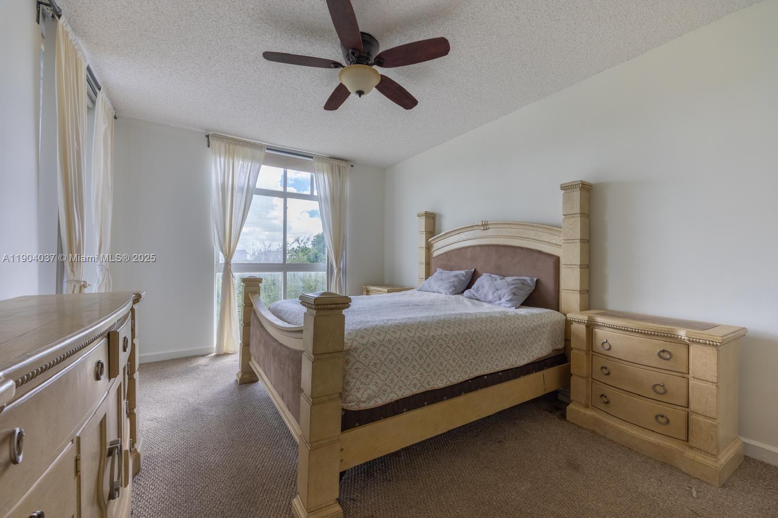 9725 Northwest 52nd Street, Unit 415 Doral, FL 33178 - Photo 9 of 24 a bedroom with a bed dresser and a window