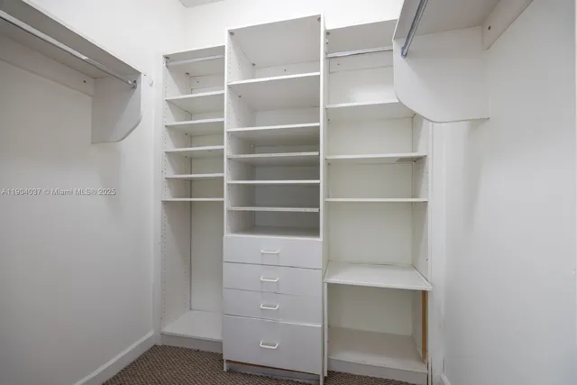 a view of walk in closet with empty racks