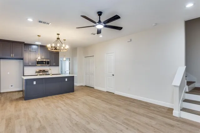 a kitchen with kitchen island white cabinets and stainless steel appliances