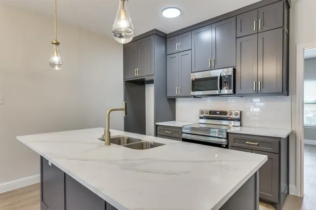 a kitchen with kitchen island a sink appliances and cabinets
