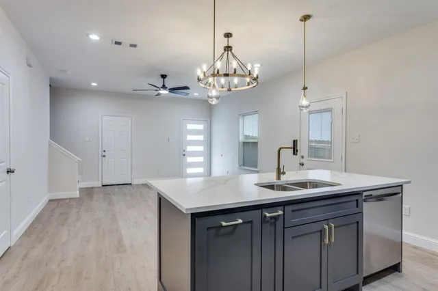 a view of a sink and dishwasher with wooden floor