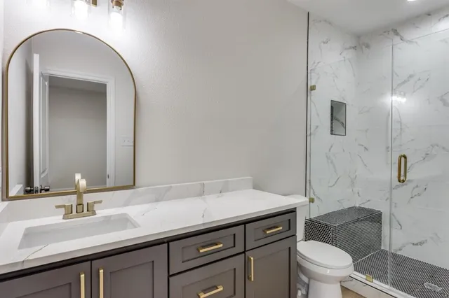 a bathroom with a sink a toilet and shower