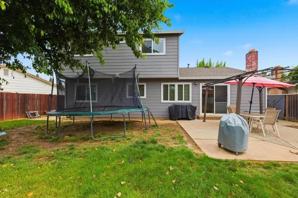 a view of backyard with table and chairs under an umbrella