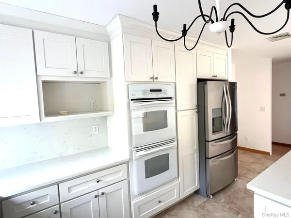 a kitchen with granite countertop white cabinets and white appliances