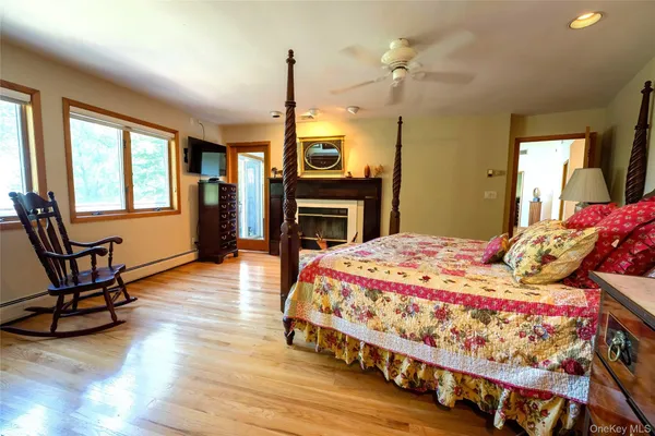 a bedroom with a bed a dresser next to a window