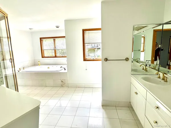 a bathroom with a tub sink and mirror