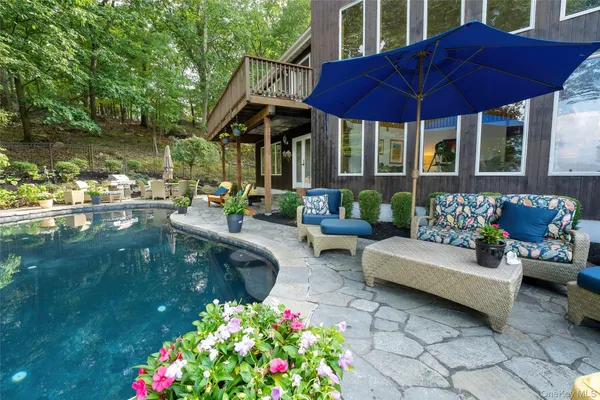 a view of a house with backyard sitting area and swimming pool