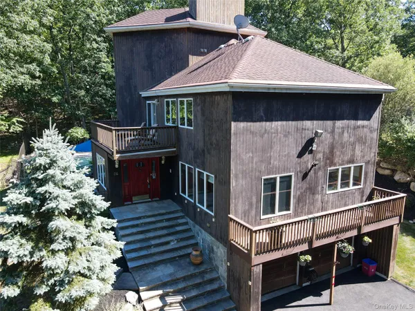 a view of house with wooden deck and furniture