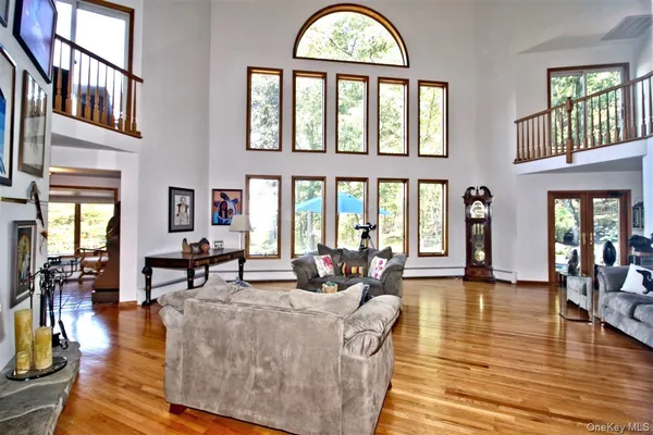 a living room with couches a dining table and couches with wooden floor