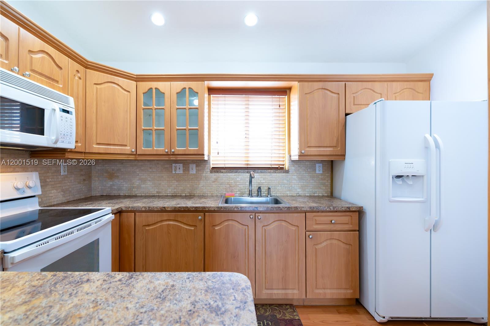 10017 West Okeechobee Road, Unit 202 Hialeah Gardens, FL 33016 - Photo 5 of 30 a kitchen with stainless steel appliances granite countertop a sink stove and refrigerator