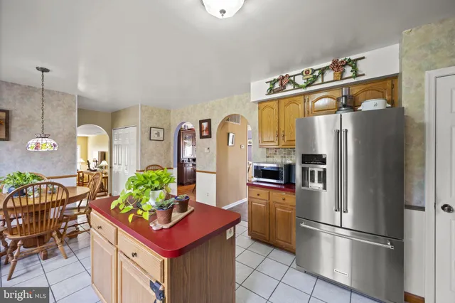 a kitchen with stainless steel appliances kitchen island granite countertop a refrigerator and a stove