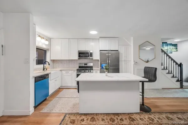 a large kitchen with kitchen island a sink stainless steel appliances and cabinets