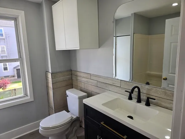 a bathroom with a sink toilet and mirror