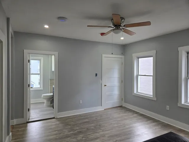 a view of an empty room and window and wooden floor