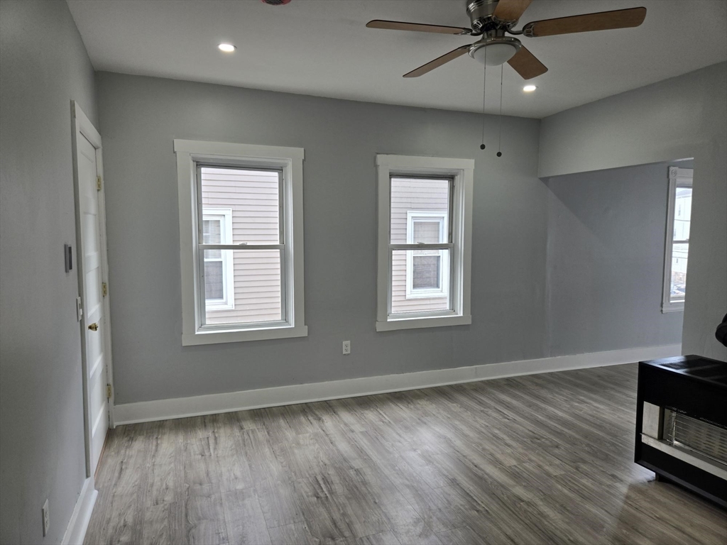 90 Quequechan Street, Unit 2 Fall River, MA 02723 - Photo 4 of 20 a view of an empty room with wooden floor and a window