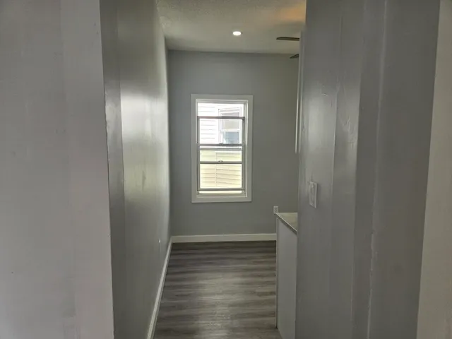 a view of a hallway with wooden floor