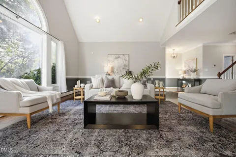 a living room with furniture a large window and a table
