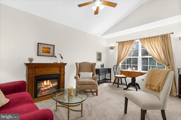 a living room with furniture a fireplace and a large window