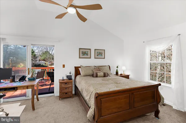 a bedroom with a bed a table and a large window