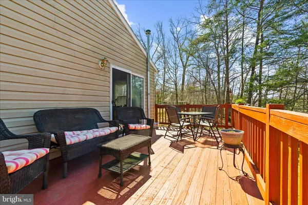 a view of a patio with chairs and table on the wooden floor