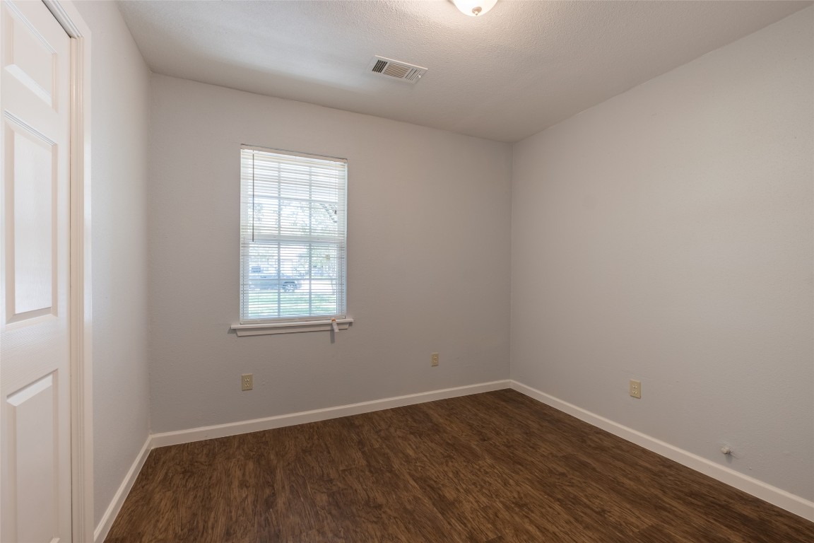 606 West Street Georgetown, TX 78626 - Photo 13 of 36 Empty room with dark wood-style flooring and a textured ceiling