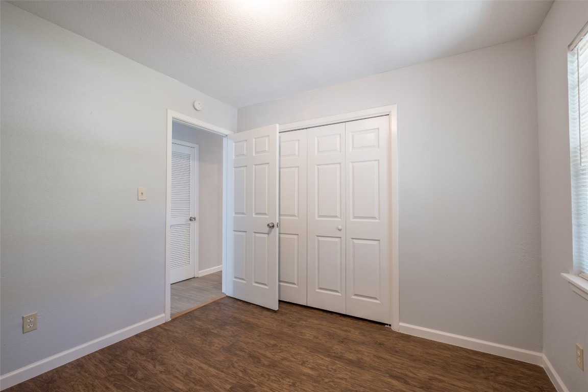 606 West Street Georgetown, TX 78626 - Photo 14 of 36 Unfurnished bedroom featuring dark wood-type flooring and a closet